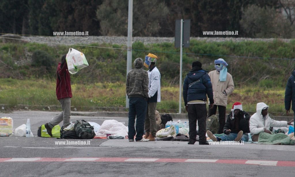 UN-IMMIGRATO-MOSTRA-AI-COMPAGNI-ALCUNE-BUSTE-ALIMENTARI-.jpg