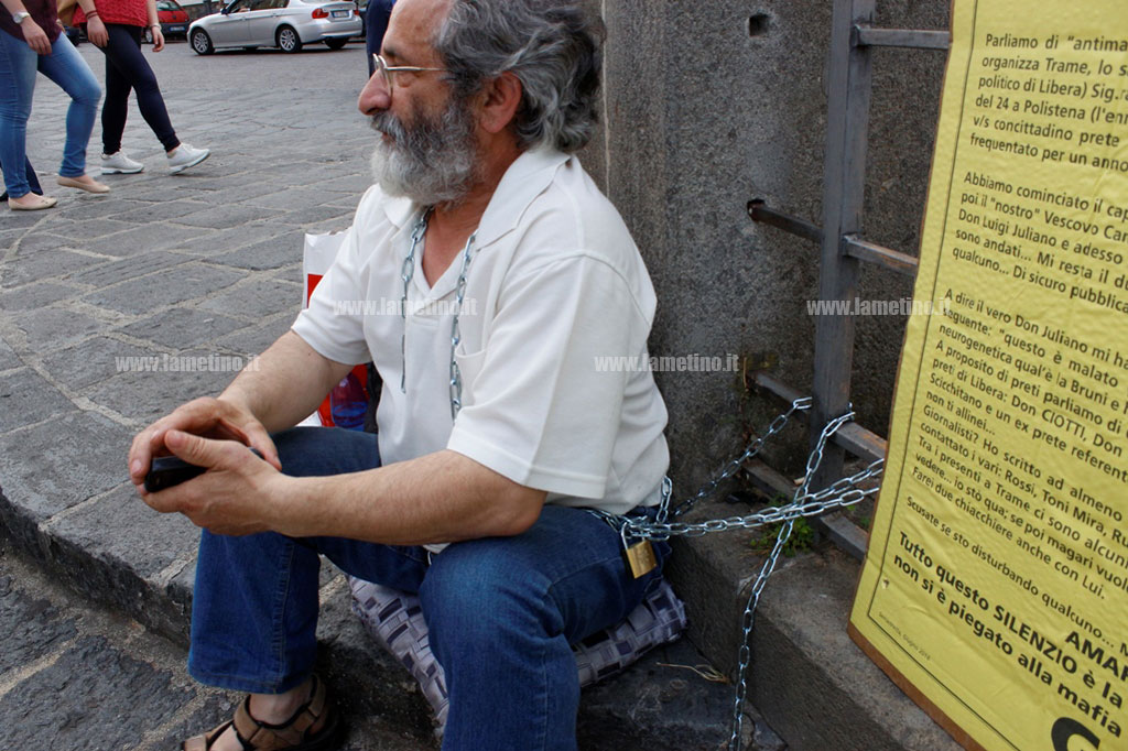 Uomo si incatena in piazzetta San Domenico durante il festival Trame